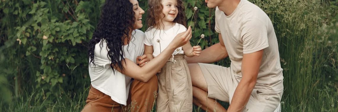 A joyful family enjoying time together in a lush green meadow, capturing love and bonding.